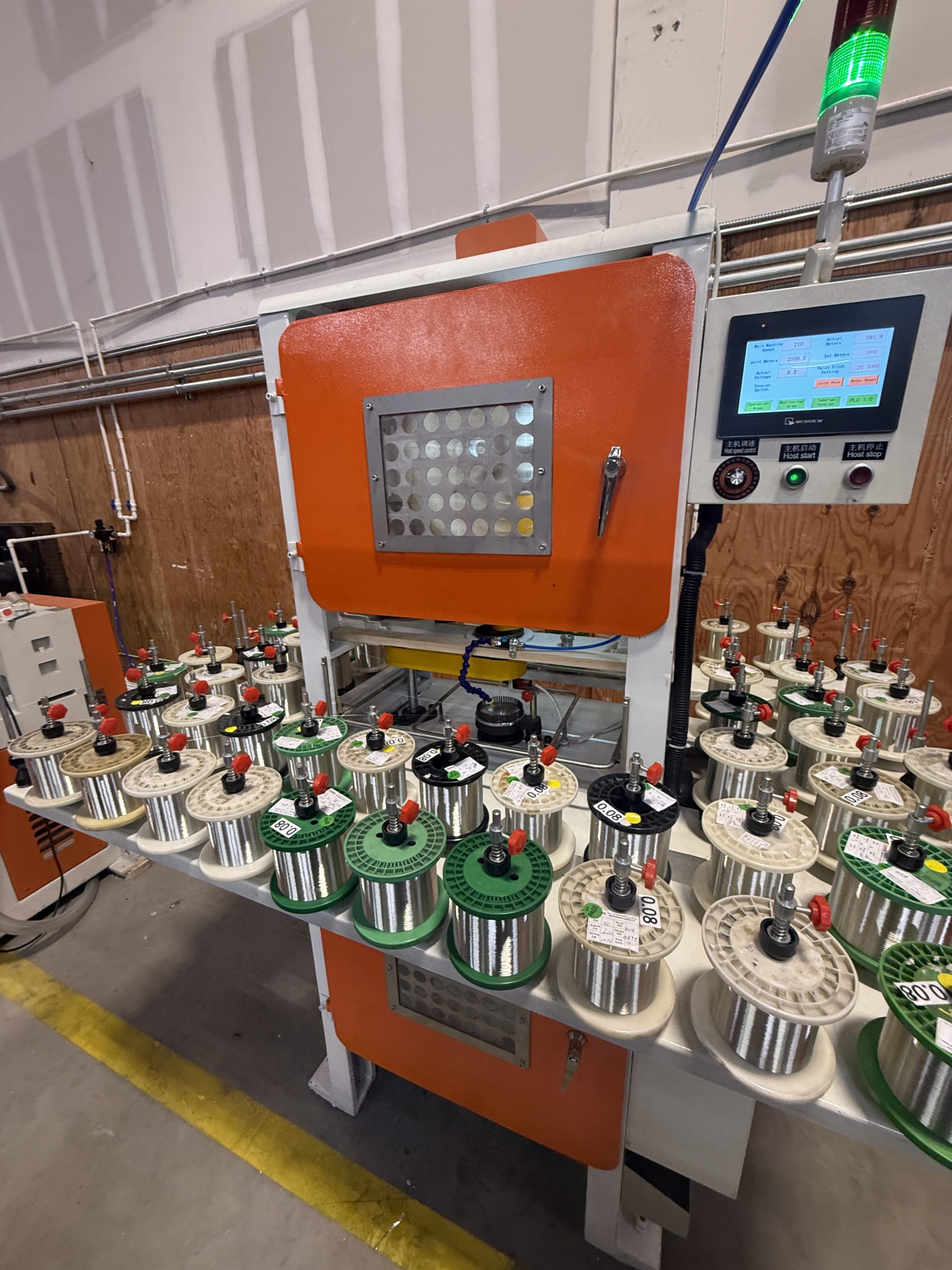 Copper braiding machine with spools of copper wire and control panel