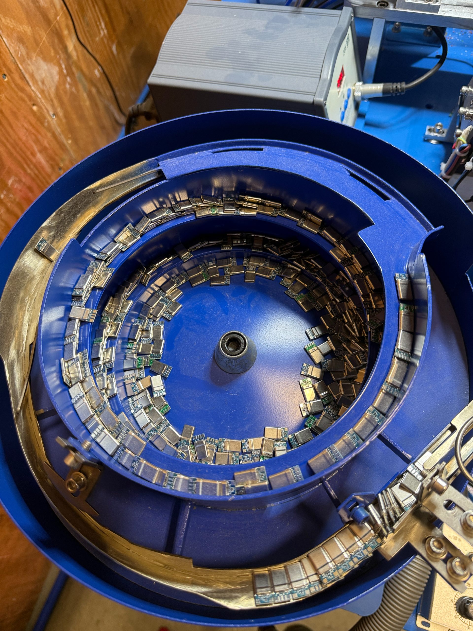 Vibratory feeder bowl sorting and aligning connector components for automated assembly